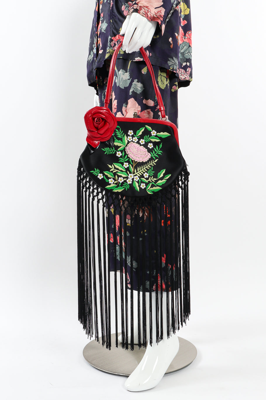 Fringe shoulder bag by Moschino held by mannequin wearing floral suit @recessla