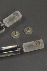 Vintage Judith Hendler Lucite Barrel Drop Earrings backs removed, closeup of tarnish and scuffing on grey backdrop @Recessla