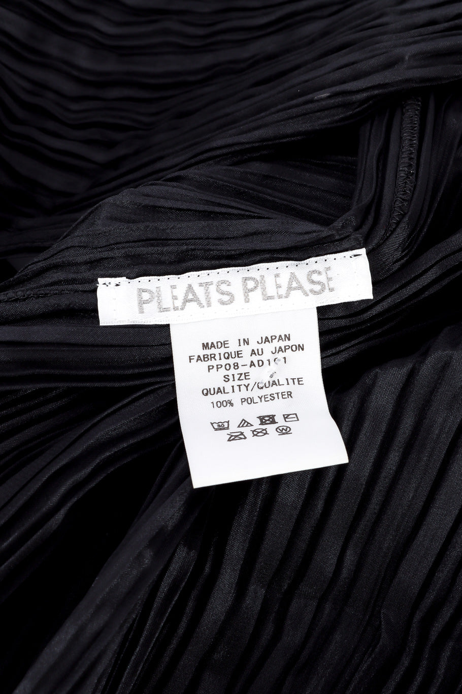Pleats Please Issey Miyake Pleated Multi-Wrap Poncho II signature label with fabric content closeup @Recessla