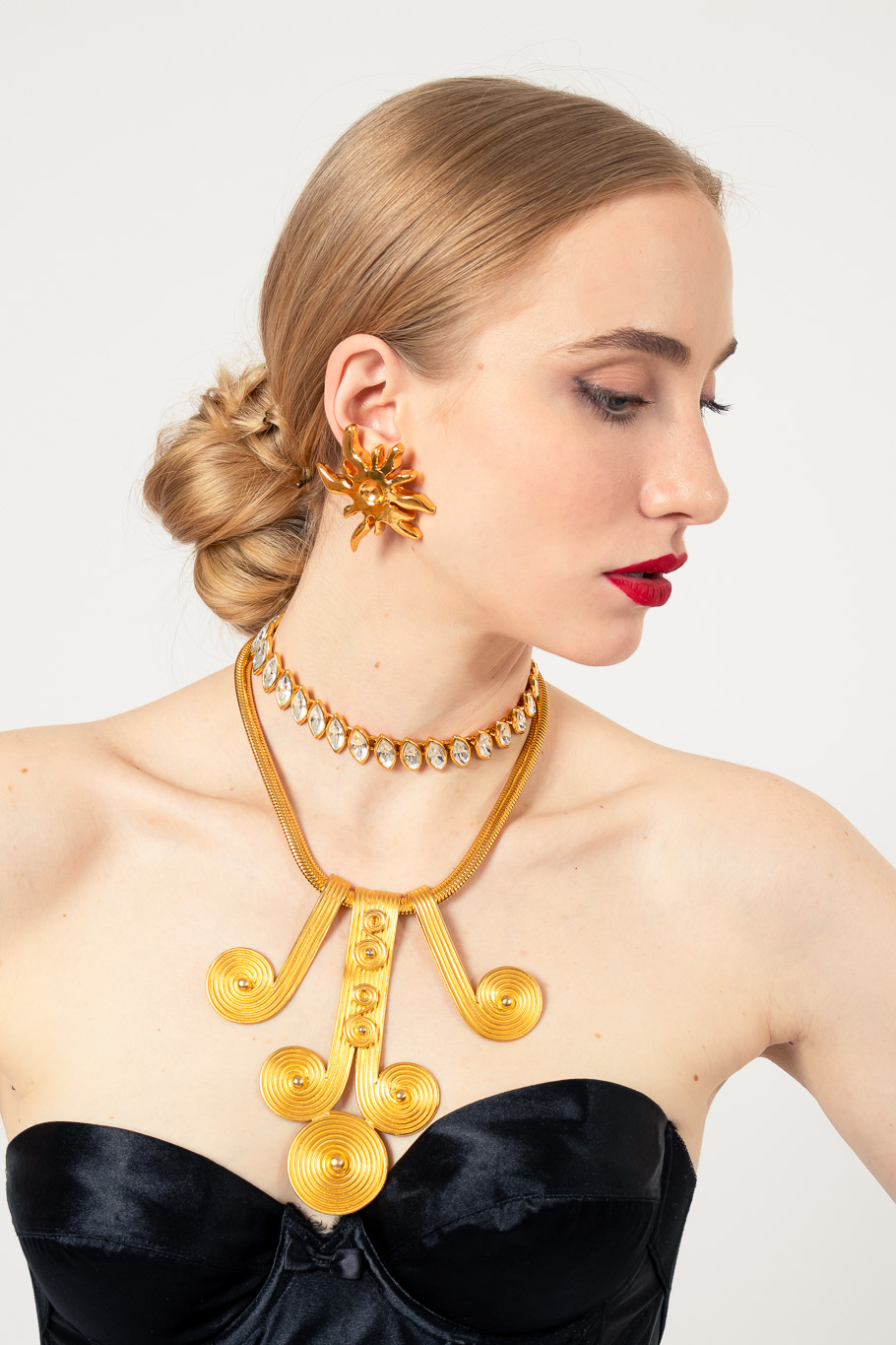 Sunburst earrings by Christian Lacroix on white background on model with necklaces @recessla
