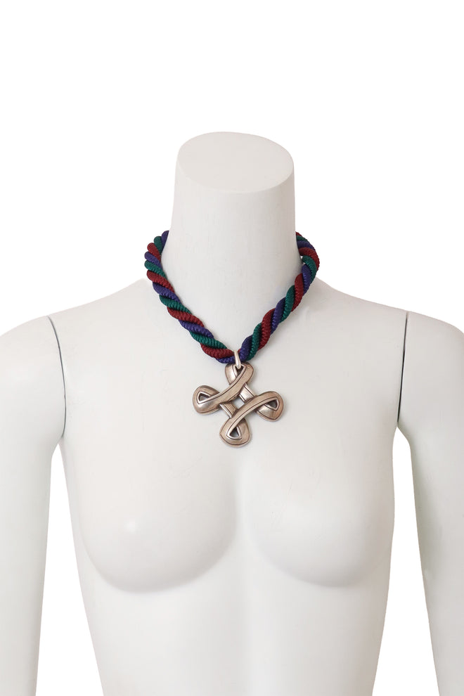 Twisted cross pendant necklace on mannequin @ Recess LA