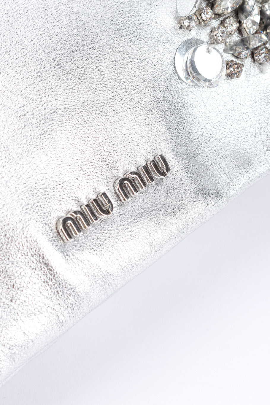 Miu Miu Metallic Drawstring Bag signature charm closeup @Recessla