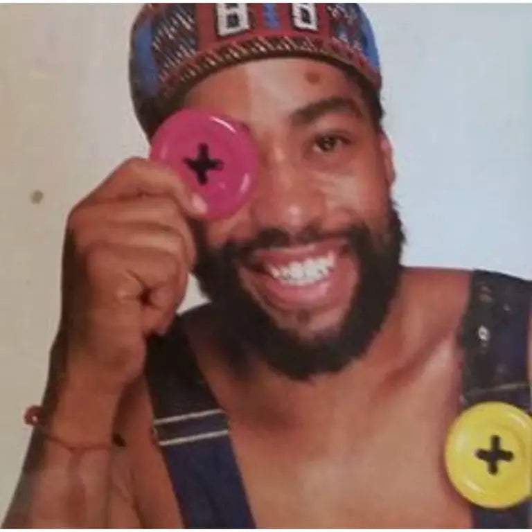 button brooch held up by Patrick Kelly in front of his eye