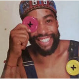 button brooch held up by Patrick Kelly in front of his eye