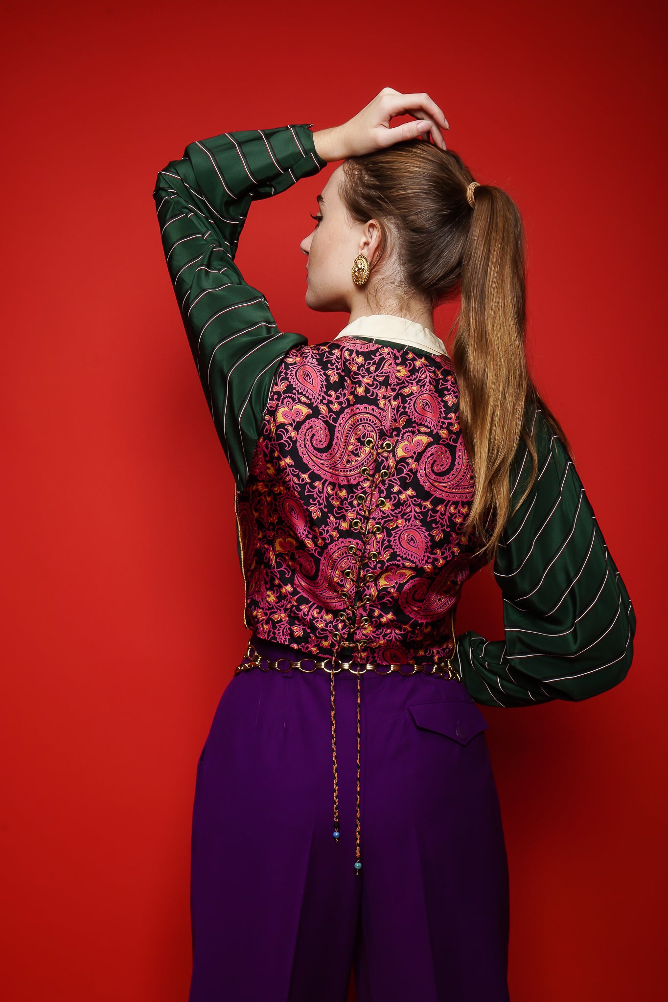 Girl in Vintage Todd Oldham Print Silk Vest, purple pant, & green stripe blouse on red @ Recess LA