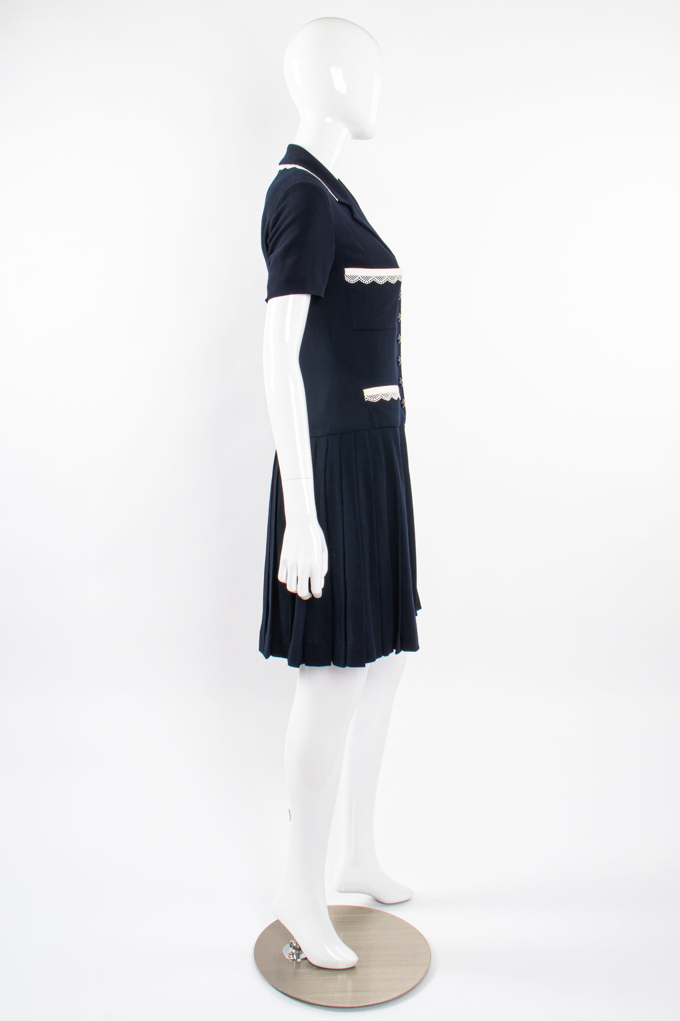 Vintage Chanel 1995C Lace Trim Pleated Uniform Dress on Mannequin side at Recess Los Angeles