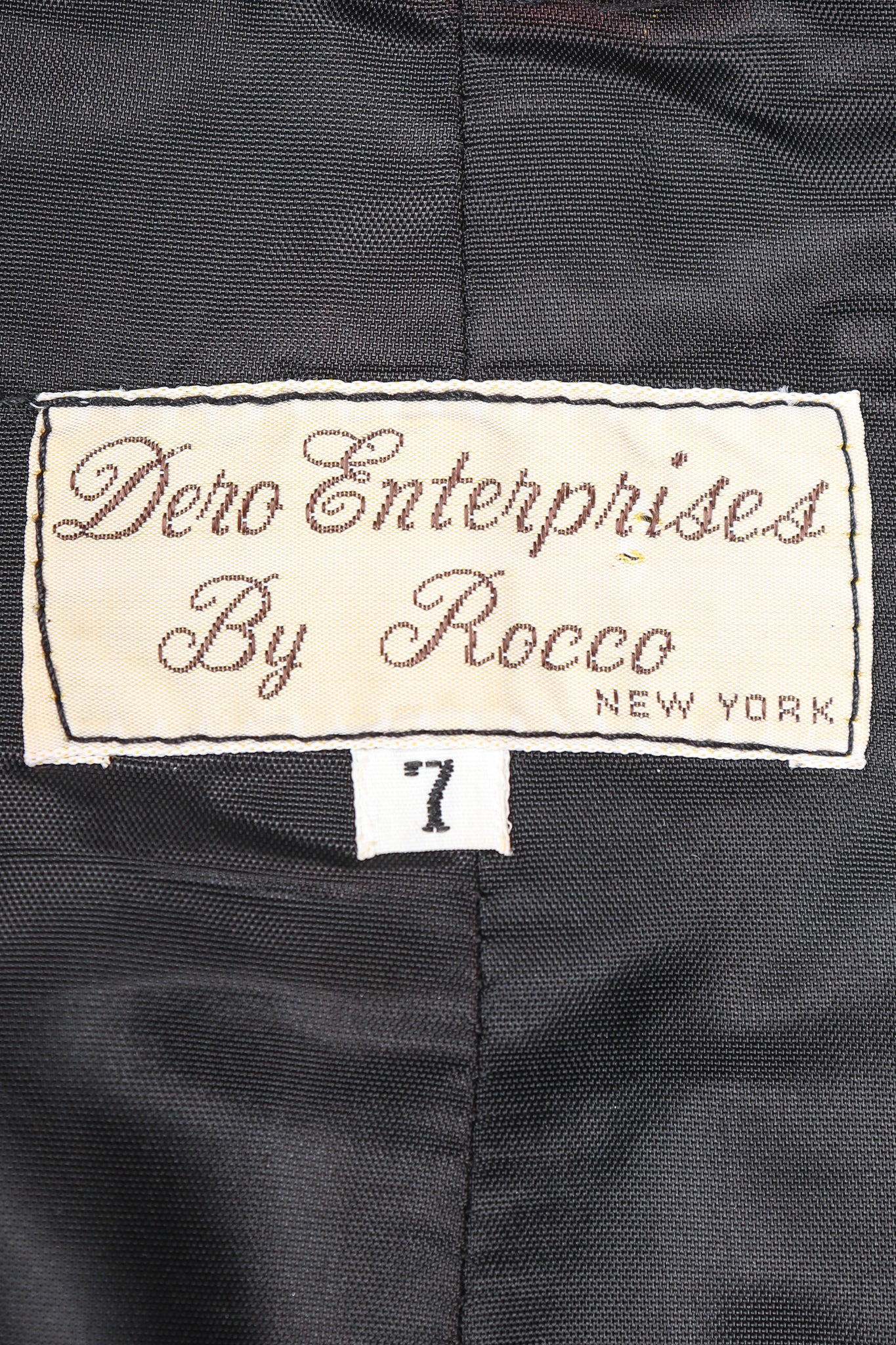 Dero Enterprises by Rocco Label on Black lining fabric at Recess Vintage