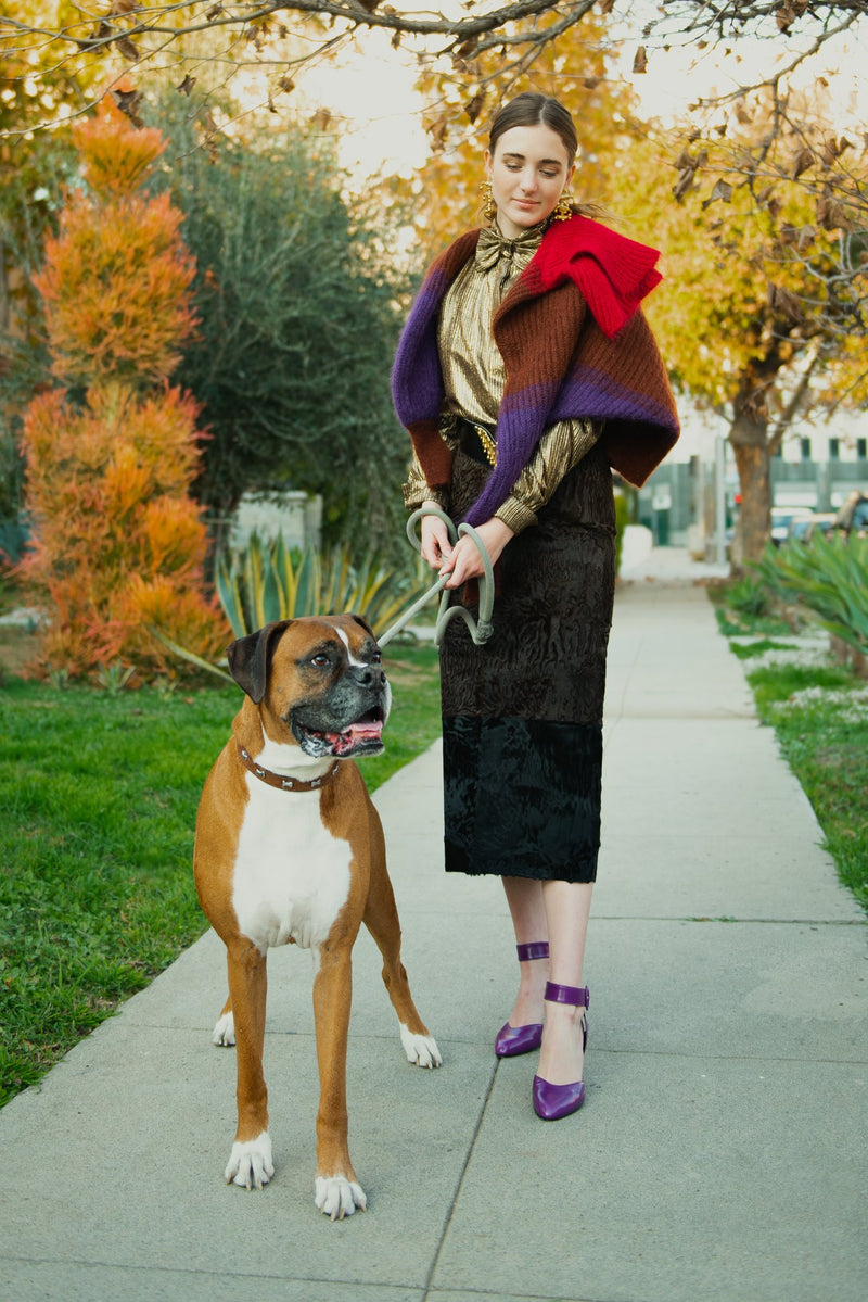 Girl in vintage Fendi Persian Lamb fur midi skirt with boxer dog on sidewalk